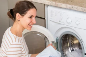 mulher a retirar roupa da maquina de lavar